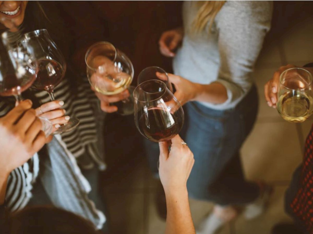 A group of people is clinking wine glasses together in what appears to be a social gathering or celebration.